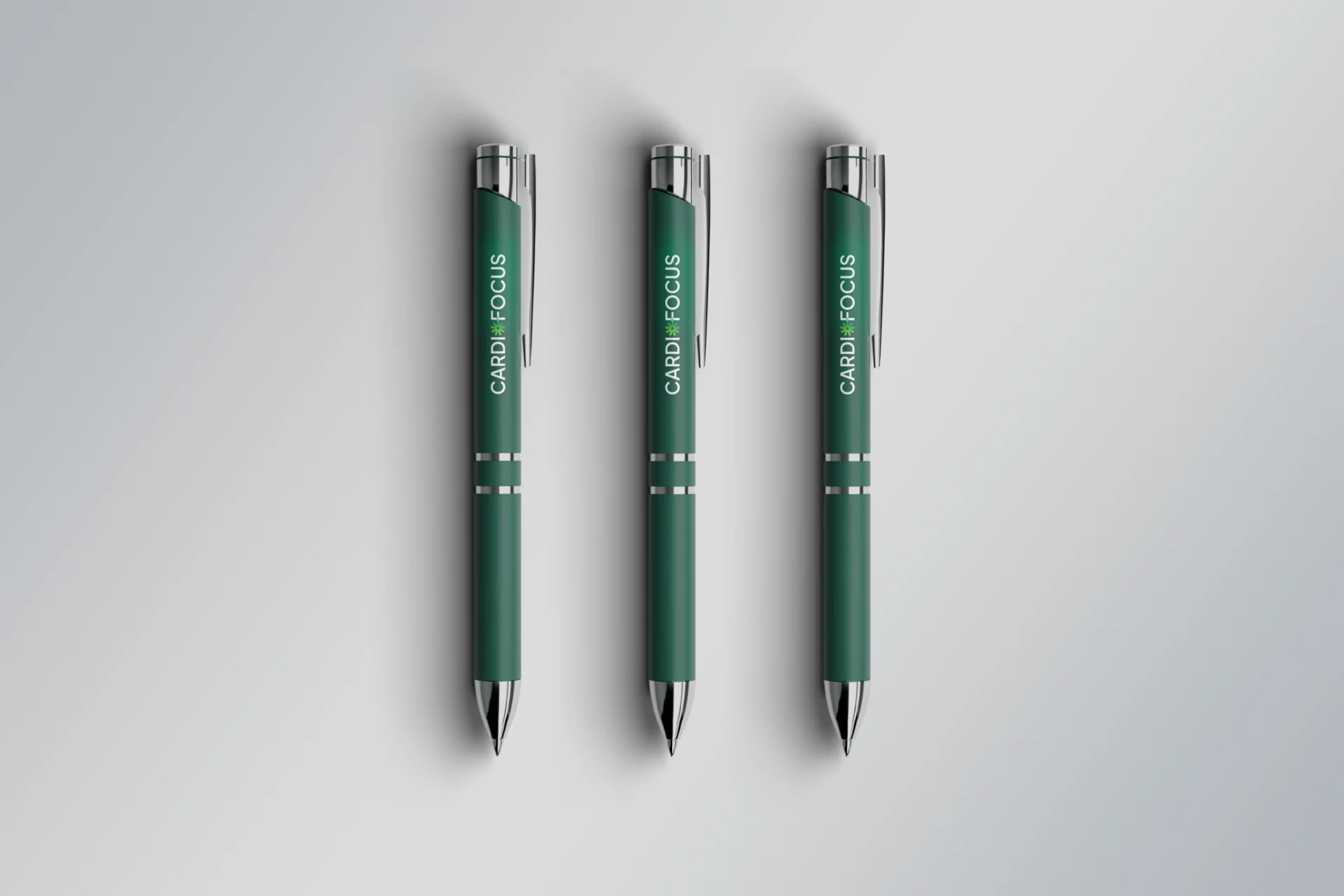 Three green CardioFocus pens on a light grey surface.